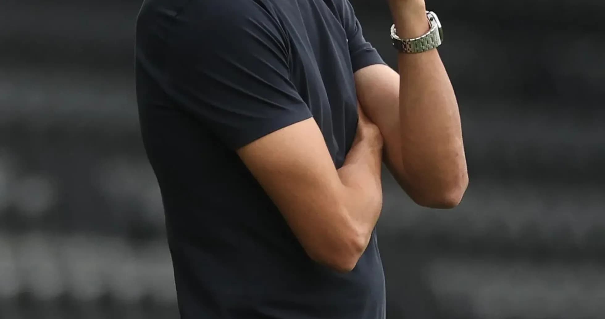 Entrenador observando el partido con gesto pensativo