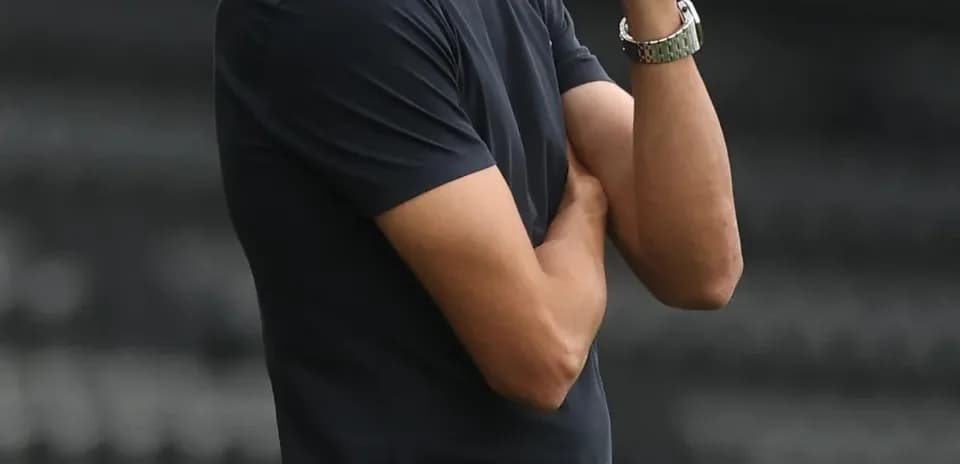 Entrenador observando el partido con gesto pensativo