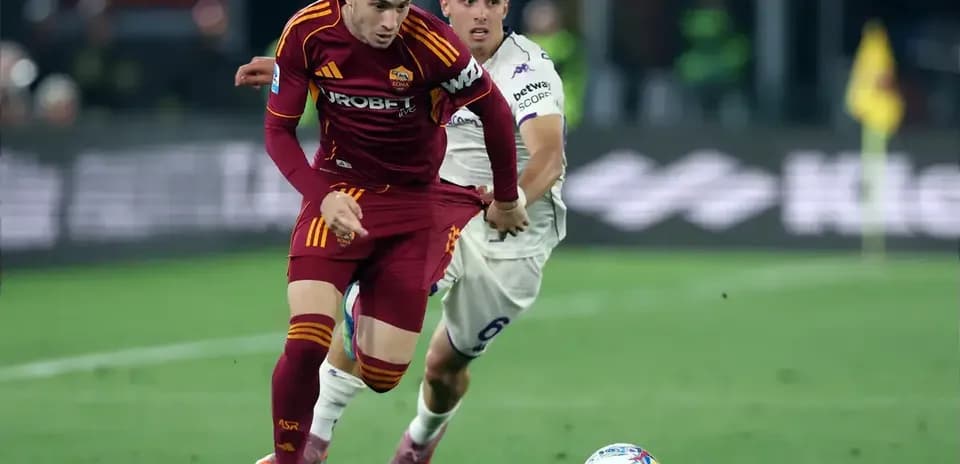 Jugador de Roma driblando mientras es seguido por oponente
