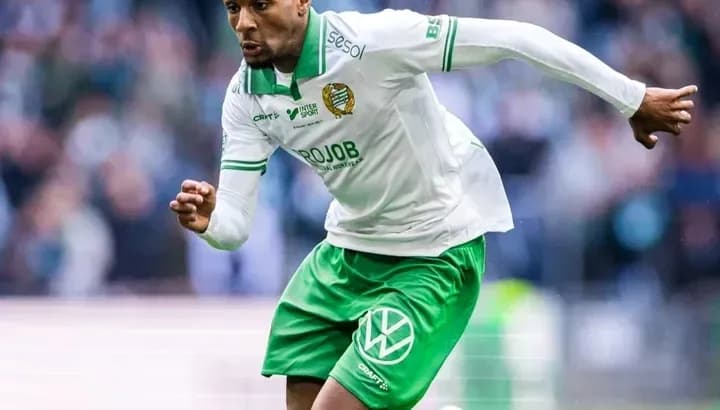 Jugador corriendo con balón en el campo de fútbol
