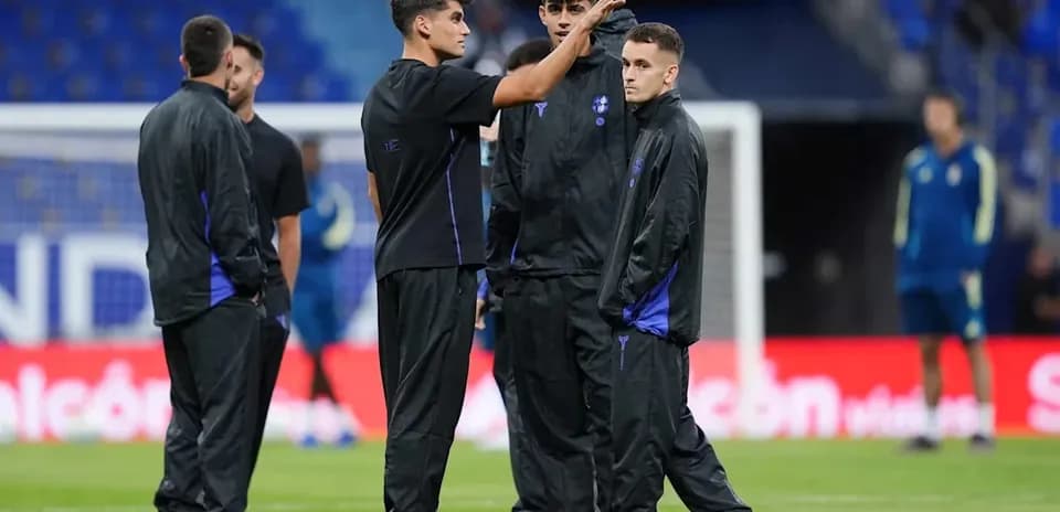 Jugadores conversando durante calentamiento en el campo