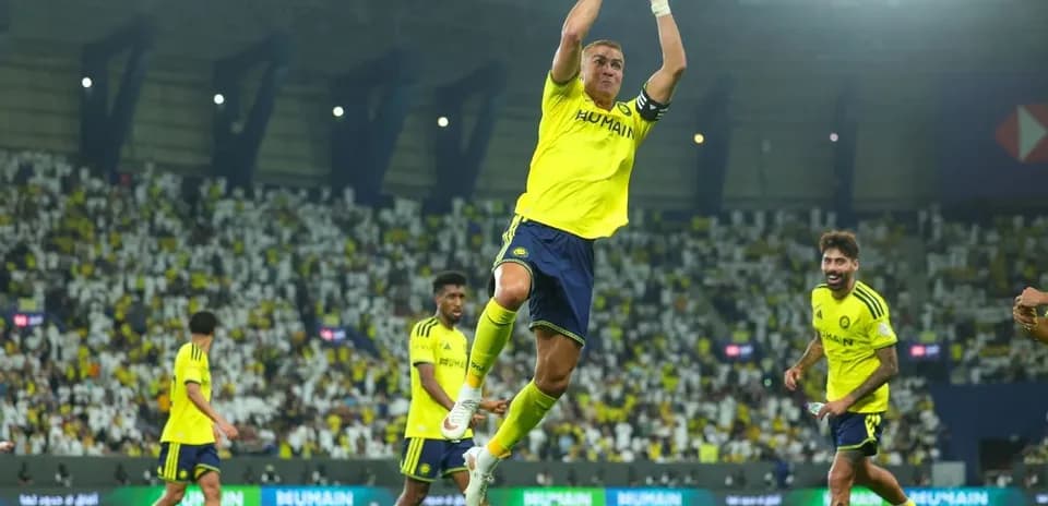 Jugador celebrando gol con compañeros en el estadio