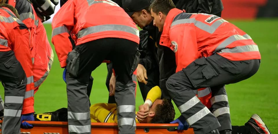 Paramédicos atendiendo a jugador en camilla