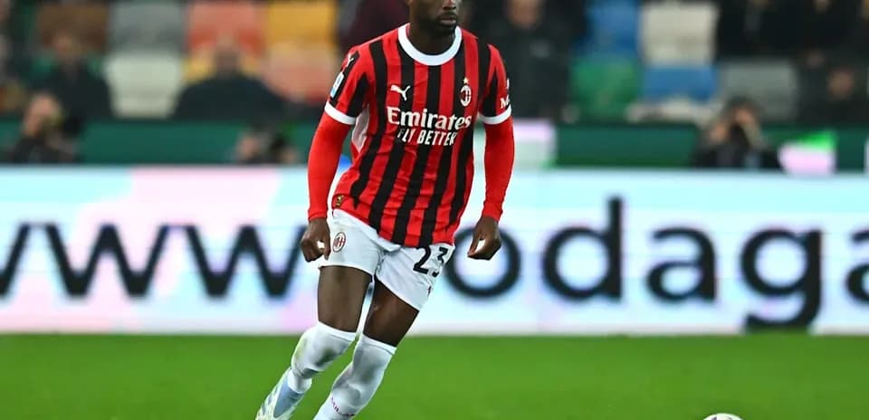 Jugador de AC Milan corriendo con el balón en campo