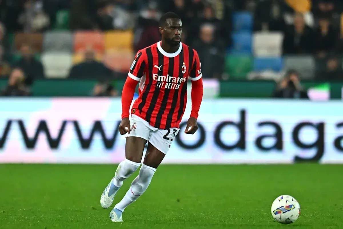 Jugador de AC Milan corriendo con el balón en campo