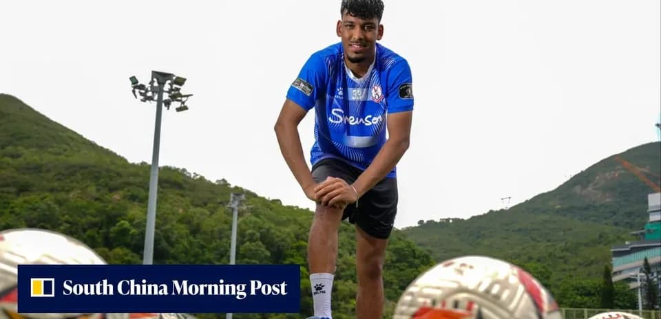 Jugador posando en campo de entrenamiento con balones