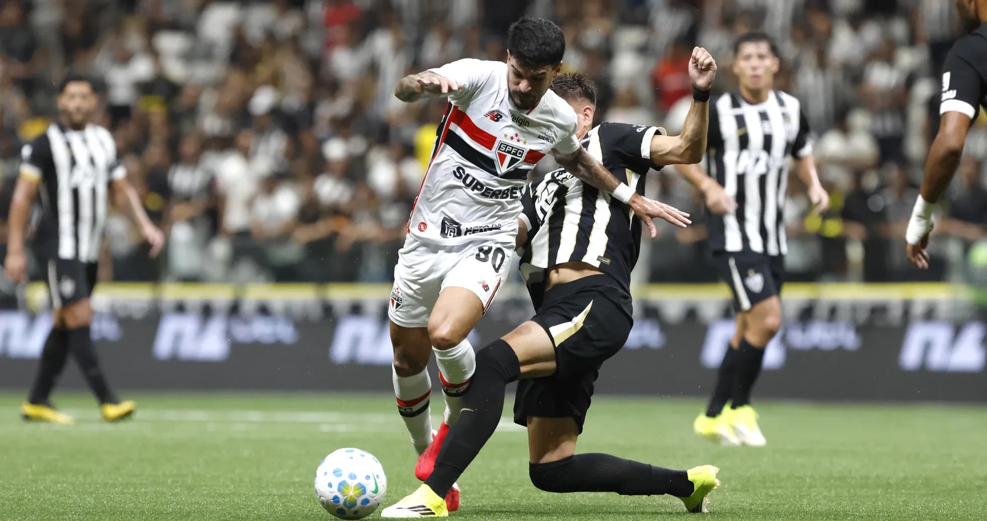 Jugador de Sao Paulo driblando a rival de Atletico-MG
