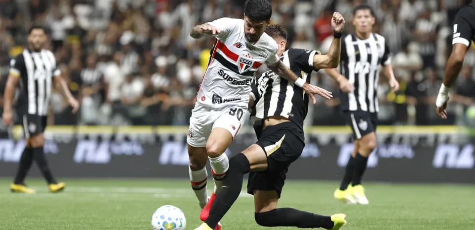 Jugador de Sao Paulo driblando a rival de Atletico-MG