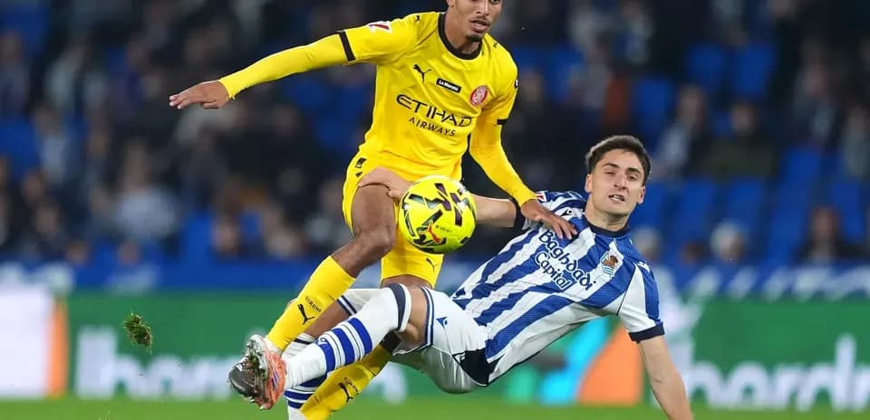 Jugador de Girona evitando a un rival de Real Sociedad