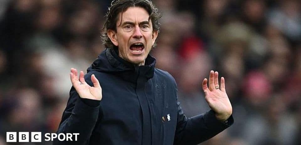 Entrenador gesticulando durante un partido de fútbol