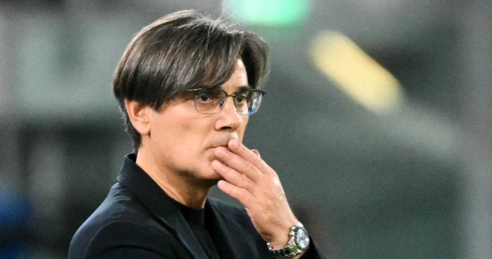 Entrenador pensativo en el banquillo durante el partido
