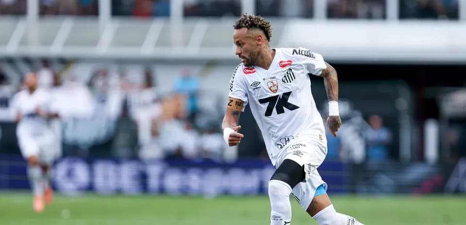 Jugador de Santos corriendo con el balón en el campo