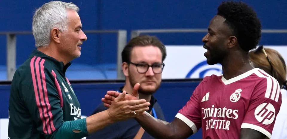 Entrenador y jugador saludándose durante el partido