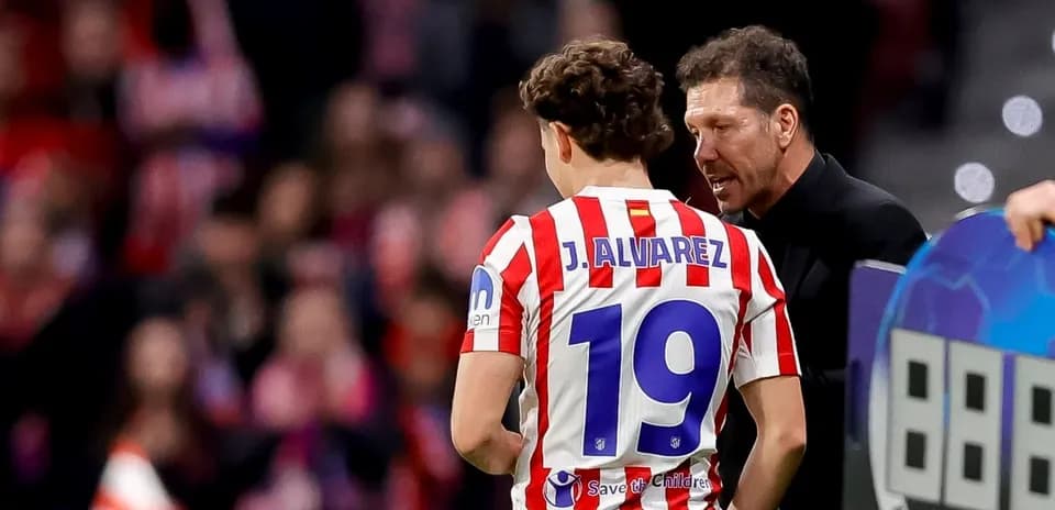 Entrenador hablando con jugador J. Álvarez en el banquillo