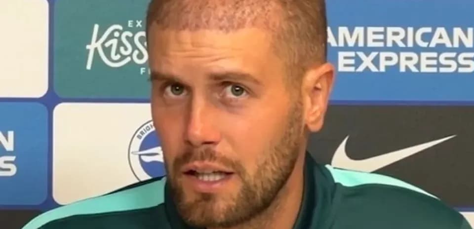 Jugador en conferencia de prensa con fondo de patrocinadores