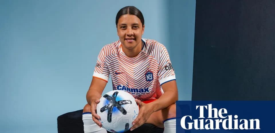 Jugadora de fútbol sosteniendo un balón en estudio
