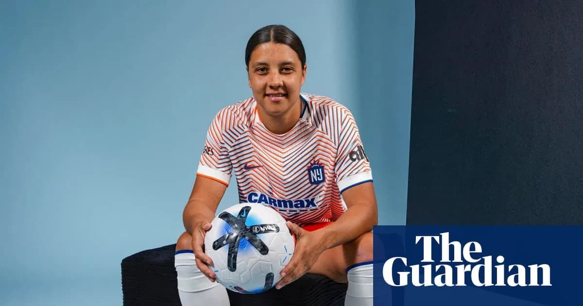 Jugadora de fútbol sosteniendo un balón en estudio