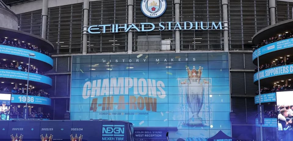 Exterior de Etihad Stadium con aficionados y decoraciones