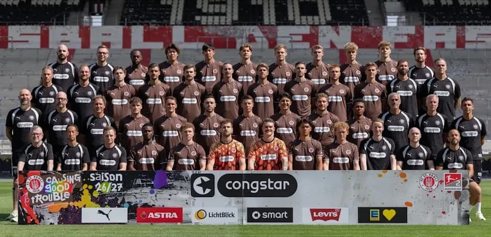 Equipo posando en el campo con camisetas marrones