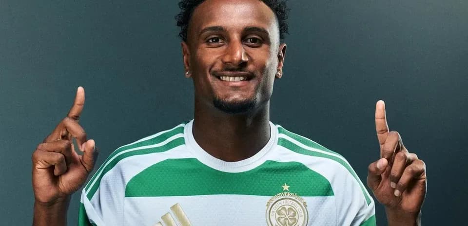 Jugador de fútbol con camiseta verde y blanca sonriendo