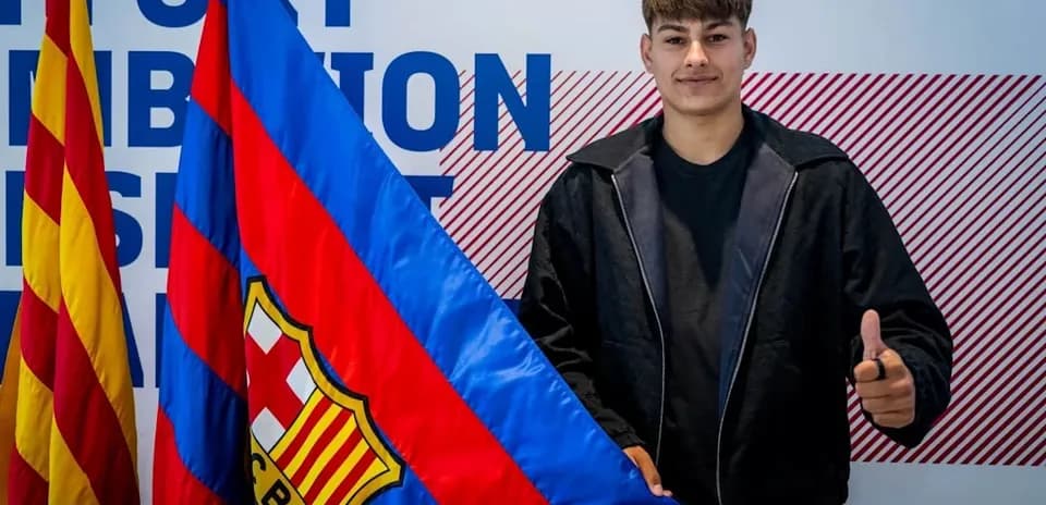 Jugador sosteniendo bandera del FC Barcelona en evento