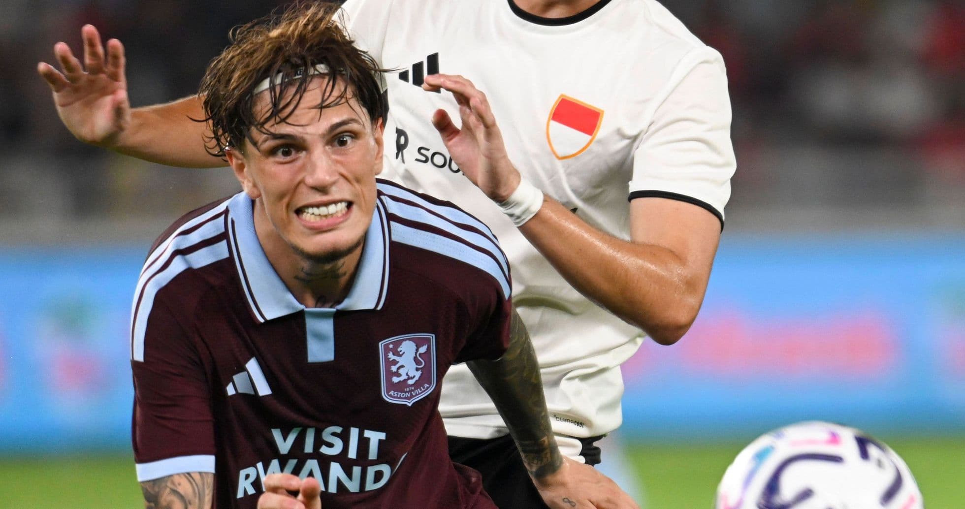 Jugador de Aston Villa siendo derribado por oponente