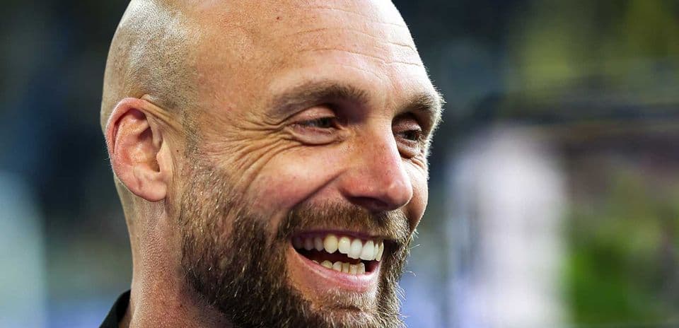 Entrenador sonriente en conferencia de prensa
