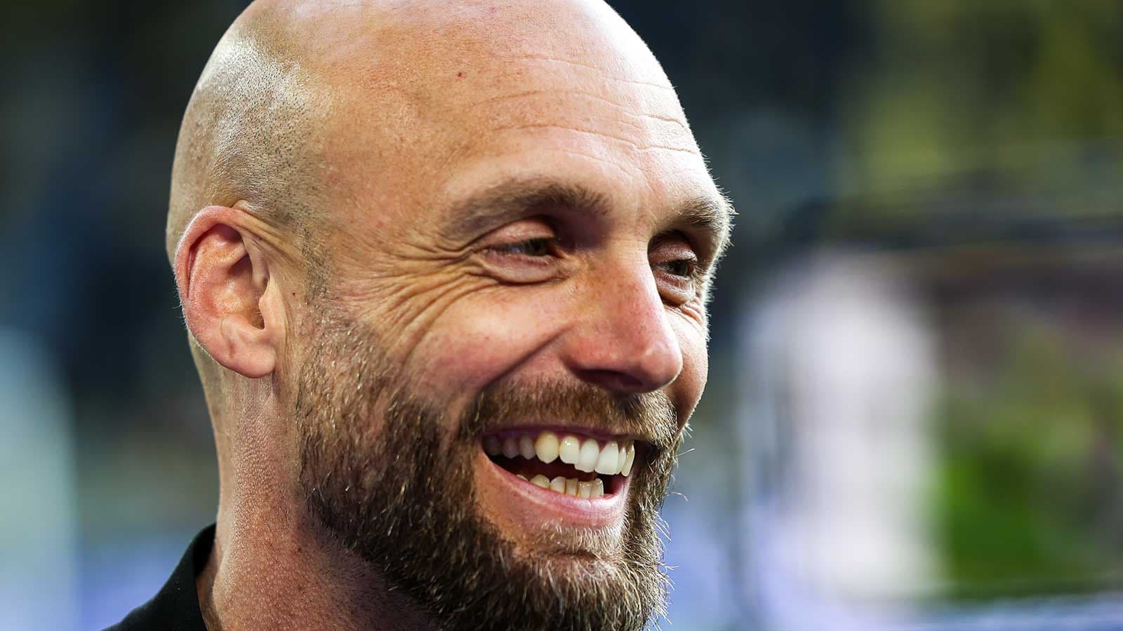Entrenador sonriente en conferencia de prensa