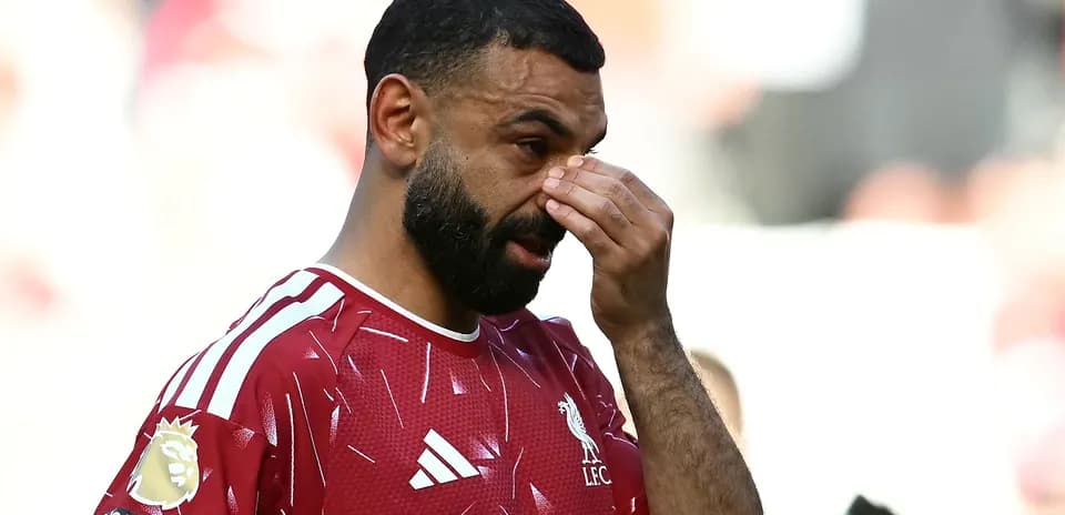 Jugador de Liverpool tocándose la cara en el campo
