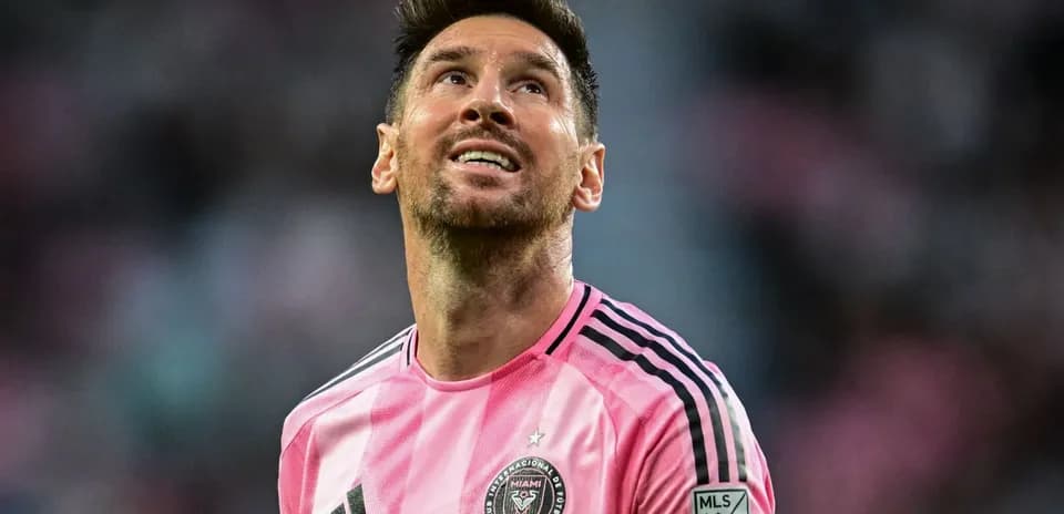 Jugador de fútbol en camiseta rosa mirando hacia arriba