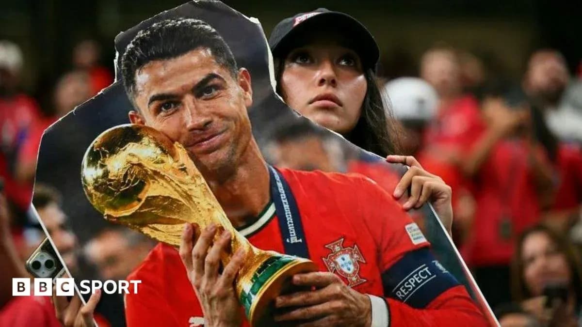 Fan holding a cutout of Cristiano Ronaldo with trophy