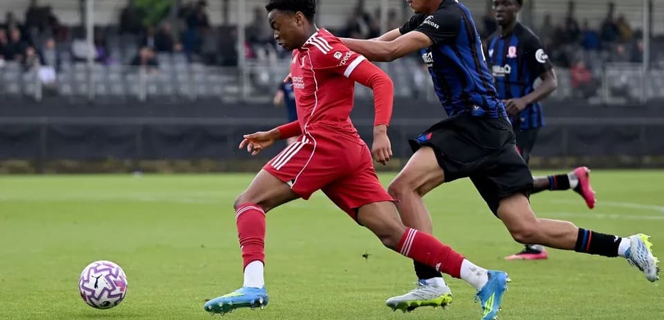 Jugador del Liverpool corriendo mientras es perseguido