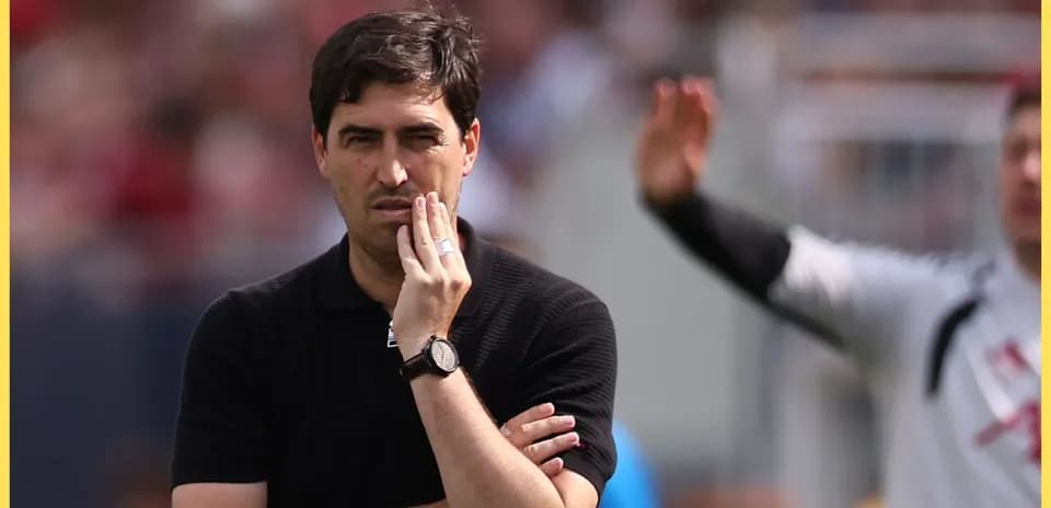 Entrenador observando el partido con expresión pensativa