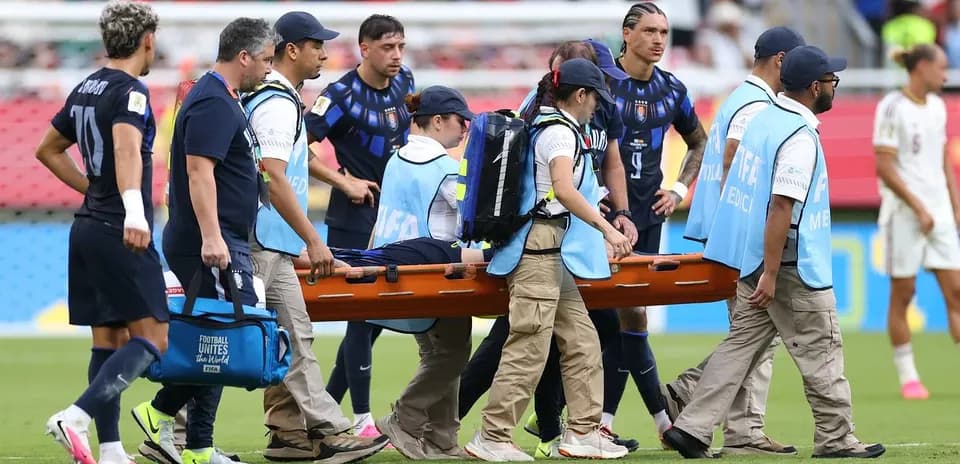Jugadores y personal médico transportando a un lesionado