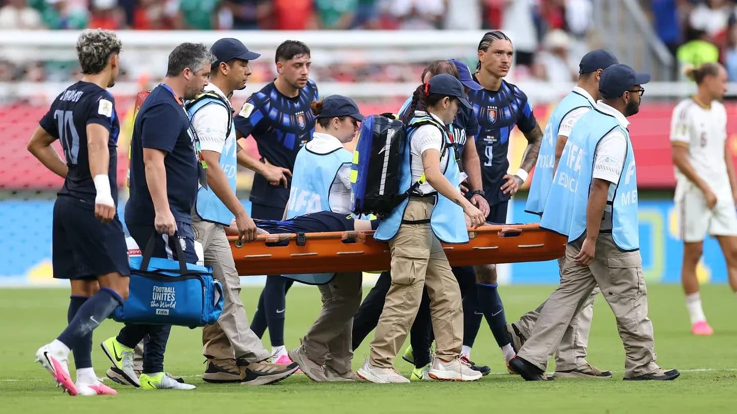 Jugadores y personal médico transportando a un lesionado