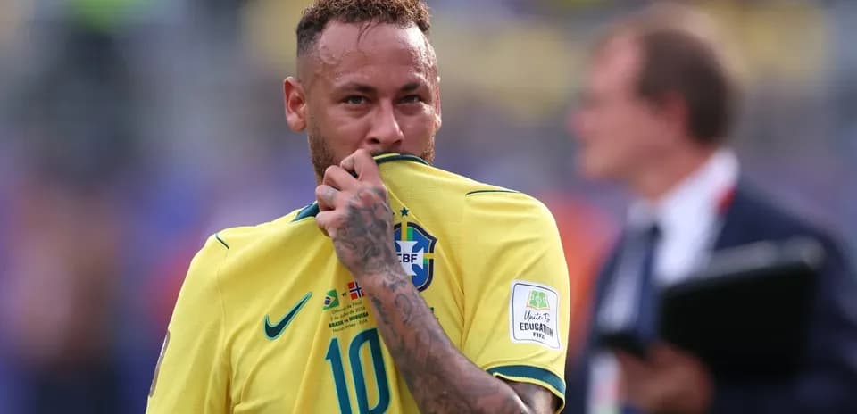 Jugador brasileño sosteniendo su camiseta durante partido