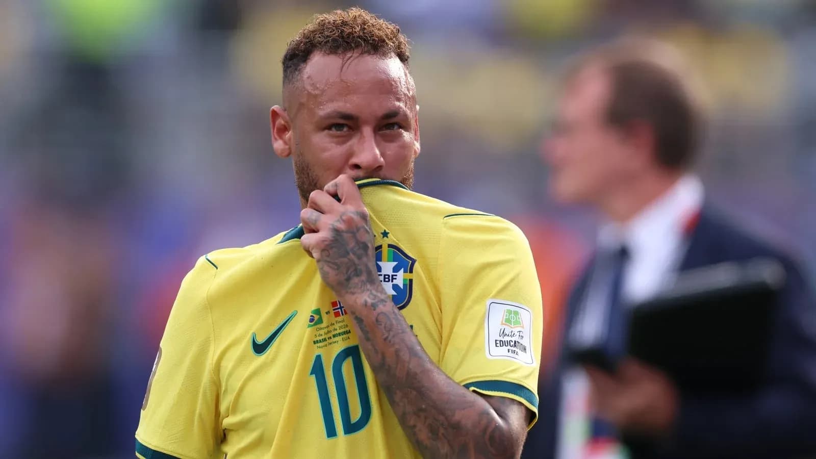 Jugador brasileño sosteniendo su camiseta durante partido