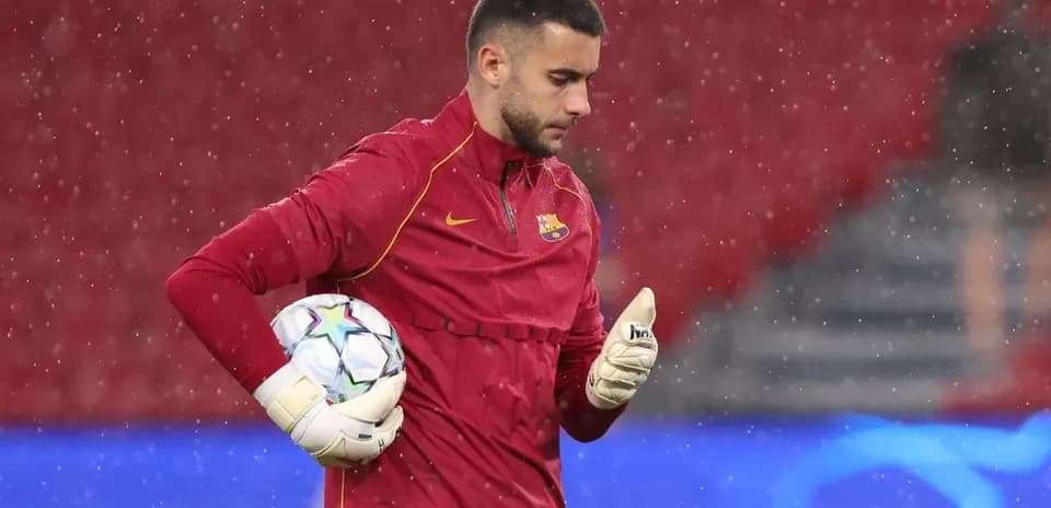 Portero entrenando con balón bajo la lluvia