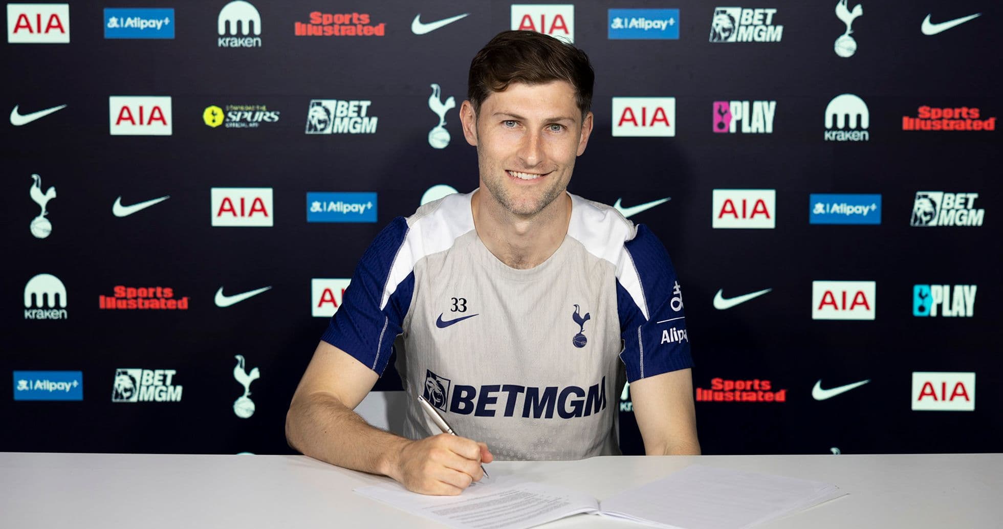 Jugador de Tottenham firmando contrato en mesa