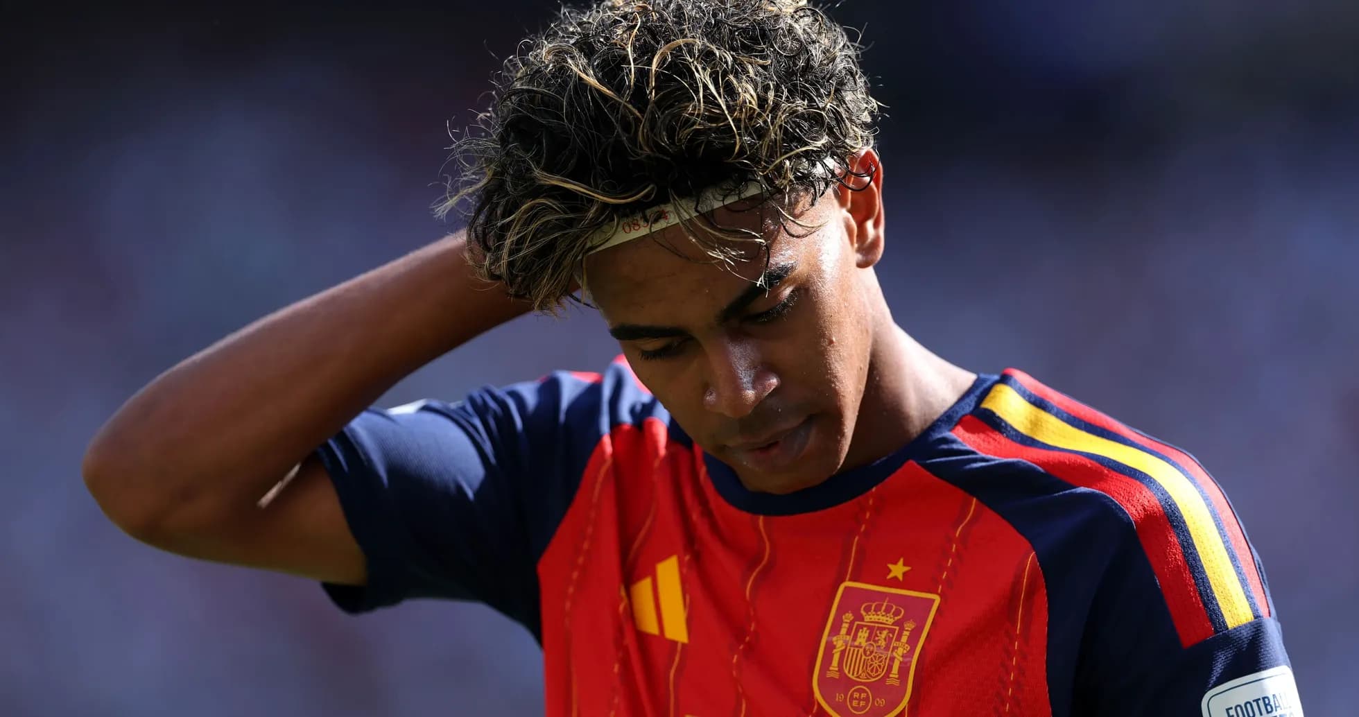 Jugador de España con camiseta roja, mirando hacia abajo Jugador de España con camiseta roja, mirando hacia abajo