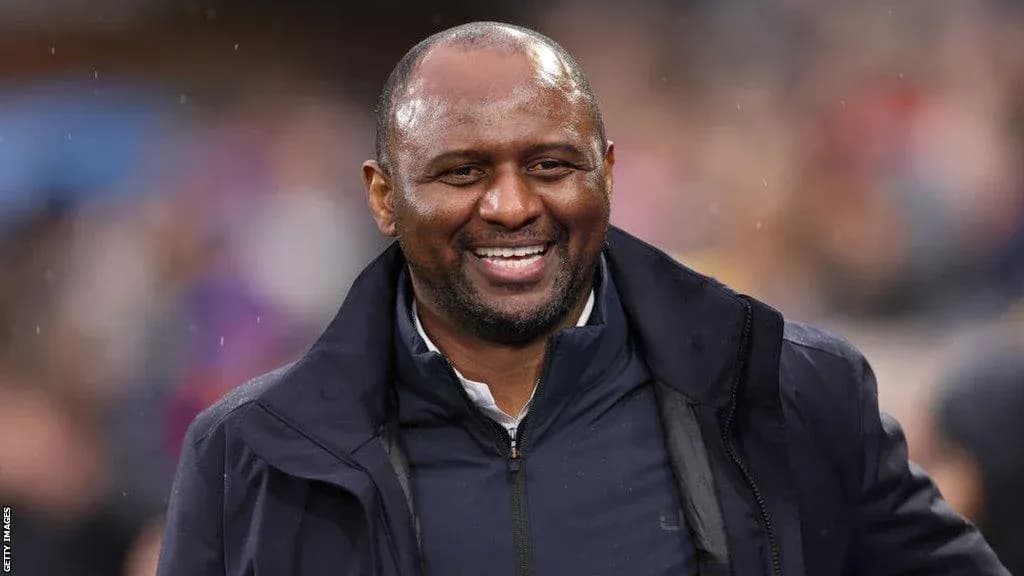 Entrenador sonriendo en el banquillo durante un partido Entrenador sonriendo en el banquillo durante un partido