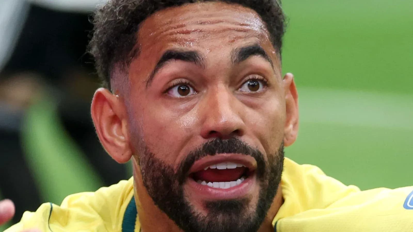 Jugador de fútbol con camiseta amarilla expresando emoción Jugador de fútbol con camiseta amarilla expresando emoción