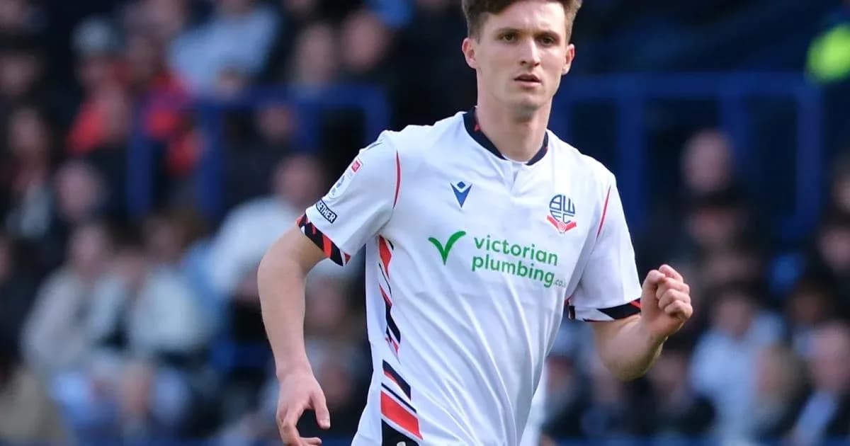 Jugador de Bolton Wanderers corriendo en el campo Jugador de Bolton Wanderers corriendo en el campo