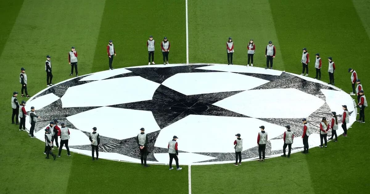 Personal en el campo alrededor del logo de la Champions Personal en el campo alrededor del logo de la Champions