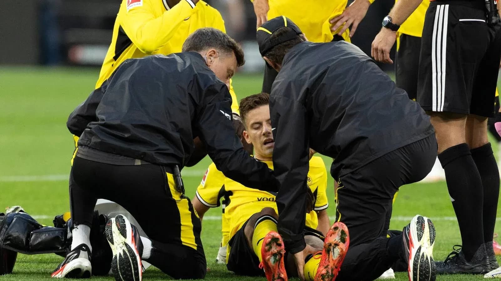 Jugadores de Dortmund atendiendo a un compañero lesionado Jugadores de Dortmund atendiendo a un compañero lesionado