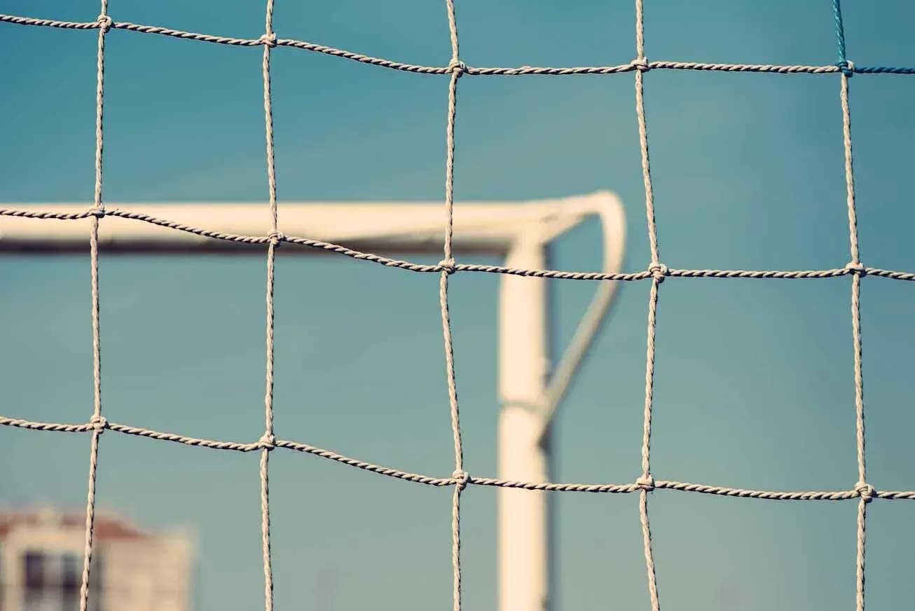 Red de gol con fondo azul y estructura de portería Red de gol con fondo azul y estructura de portería