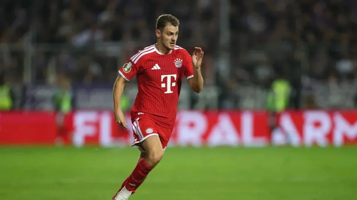 Jugador de Bayern Munich corriendo con balón en el campo Jugador de Bayern Munich corriendo con balón en el campo
