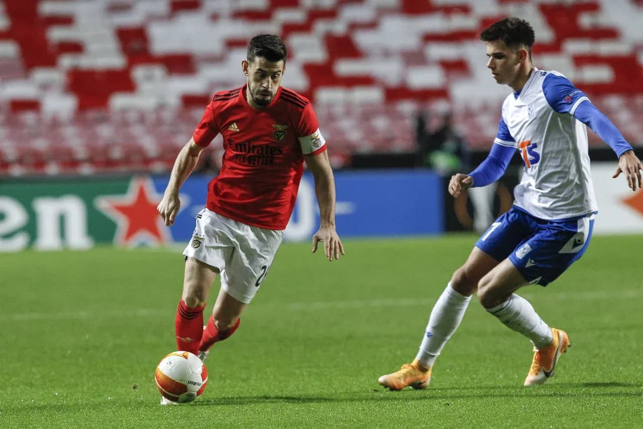 Jugador de Benfica driblando a un rival de Lech Poznan Jugador de Benfica driblando a un rival de Lech Poznan