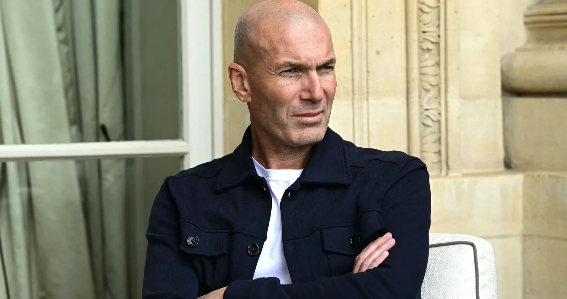 Hombre con camiseta blanca y chaqueta oscura sentado Hombre con camiseta blanca y chaqueta oscura sentado