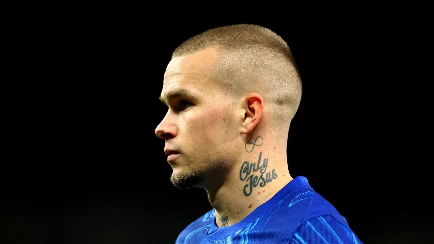 Jugador en perfil con tatuajes visibles y camiseta azul Jugador en perfil con tatuajes visibles y camiseta azul